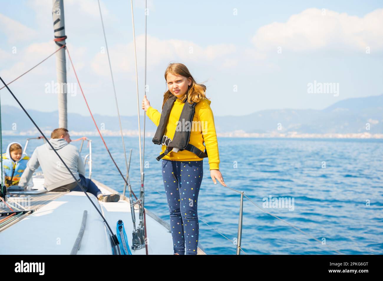 Voyage sail on sport sea luxury yacht. Yachting family summer vacation cruise. Children, sailor kid girl sailing in little safe life jacket. Ocean shi Stock Photo