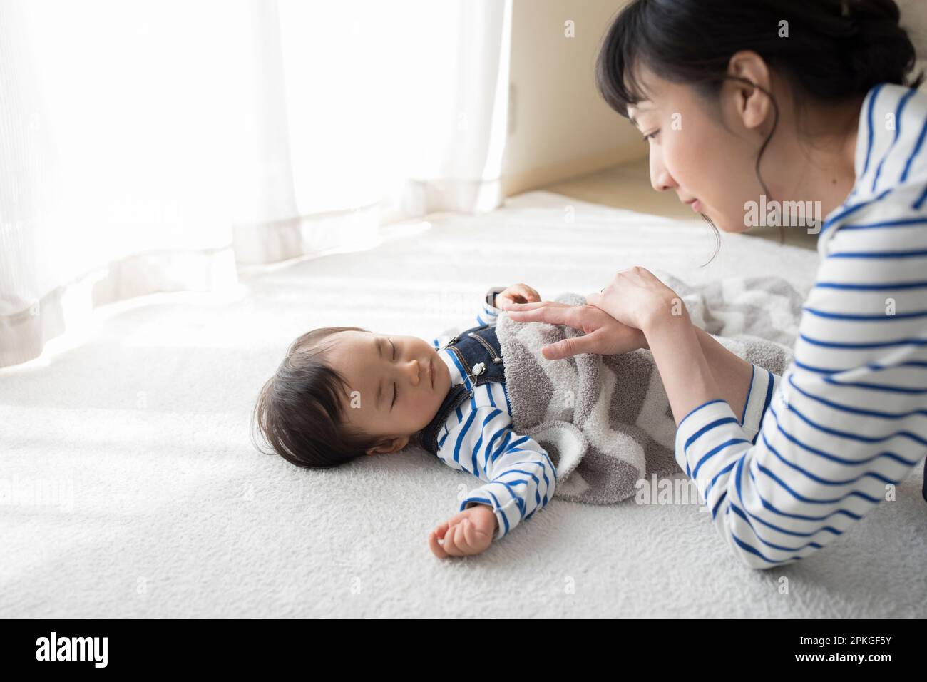 Mother napping with napping baby Stock Photo