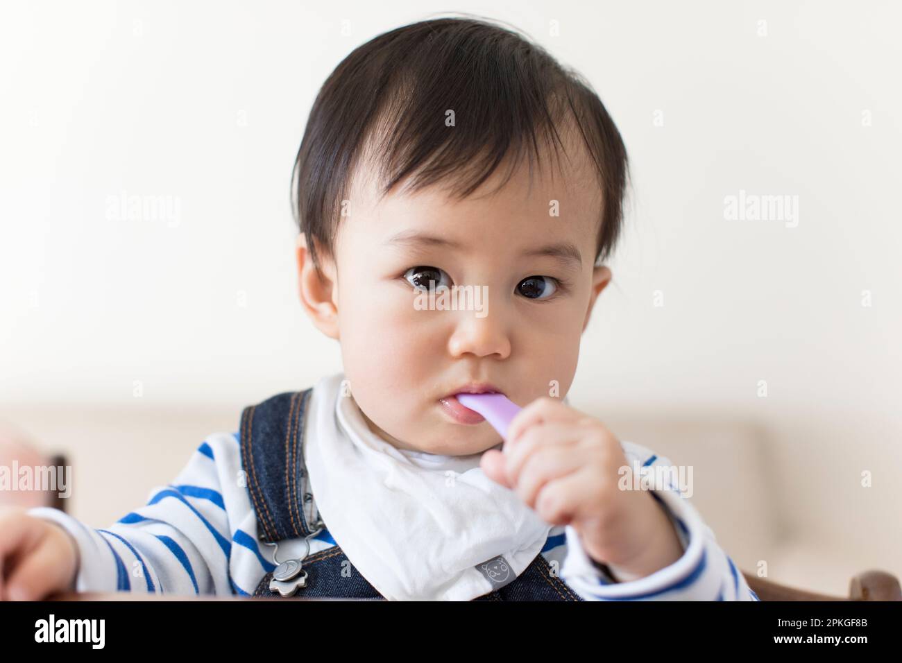 Baby eating with a spoon Stock Photo Alamy