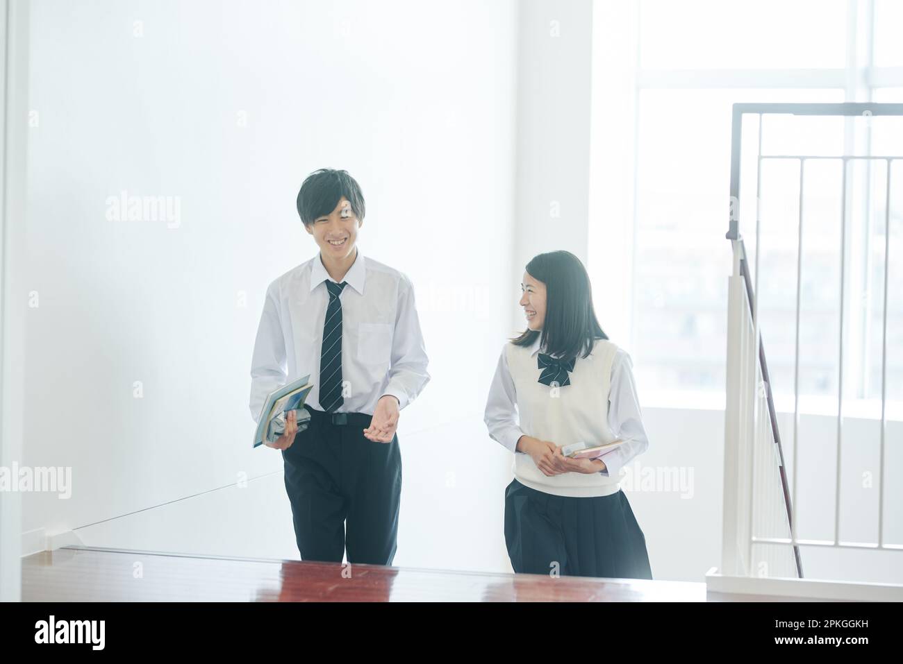 Male and female high school students talking as they move to a classroom Stock Photo