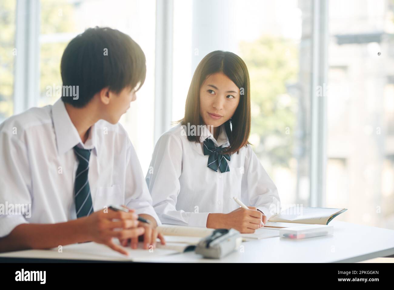 Male and female high school students studying in the study room Stock Photo