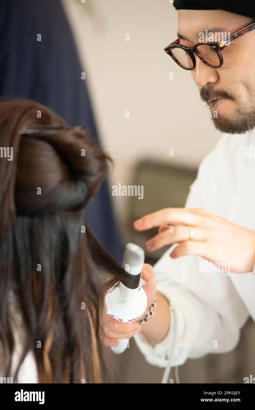 Hairdresser doing woman's hair Stock Photo - Alamy