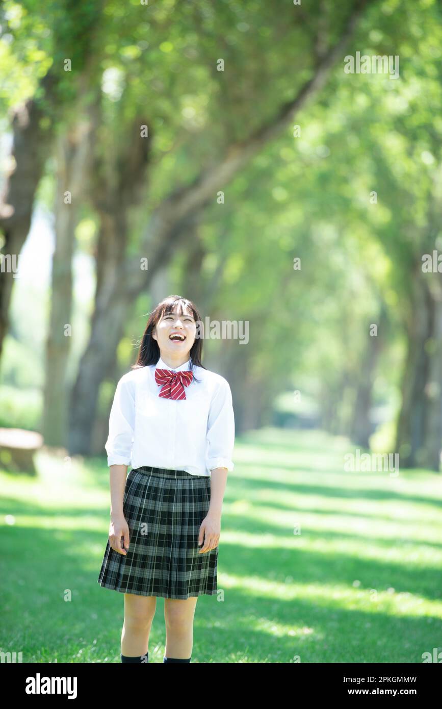 Female student smiling at a row of poplar trees Stock Photo - Alamy