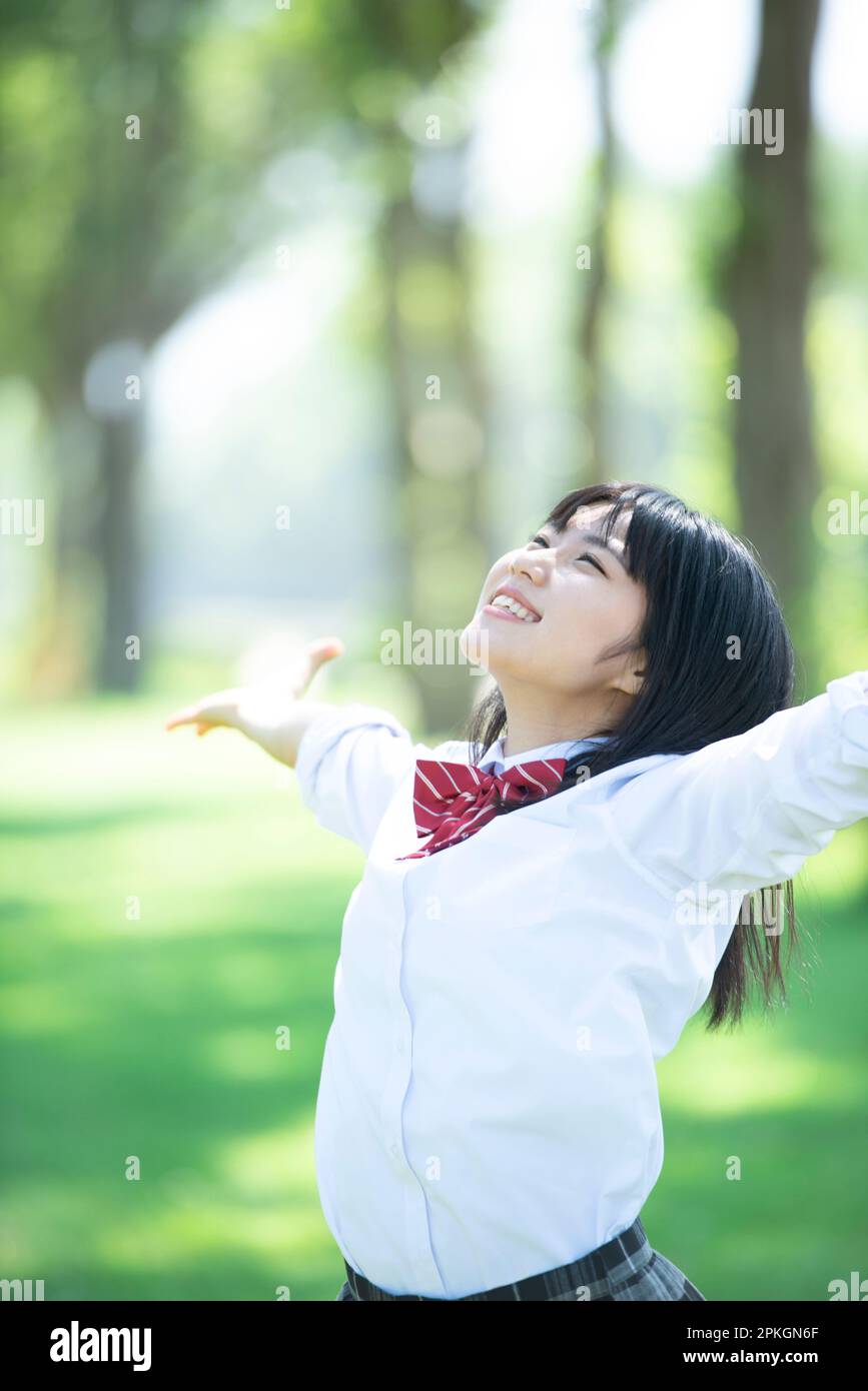 Female student spreading her hands in a row of poplar trees Stock Photo ...