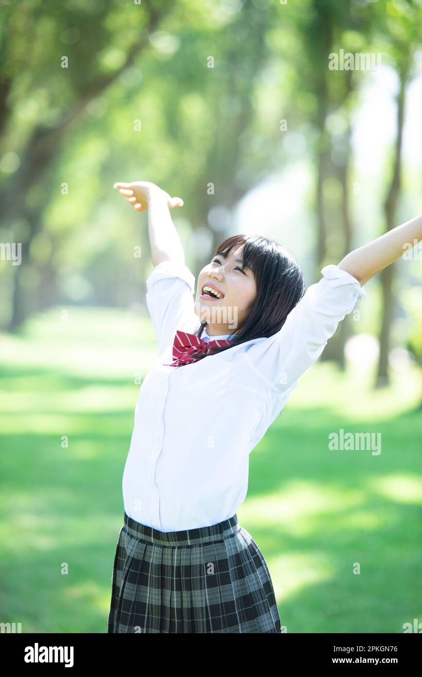 Female student spreading her hands in a row of poplar trees Stock Photo ...