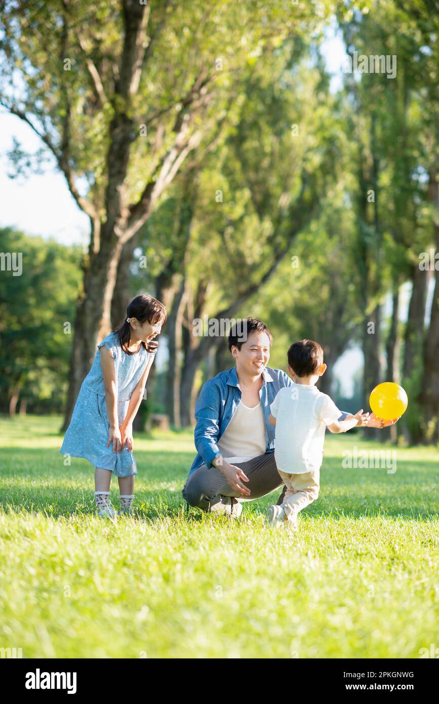 Parent and child playing at poplar-lined avenue of trees Stock Photo