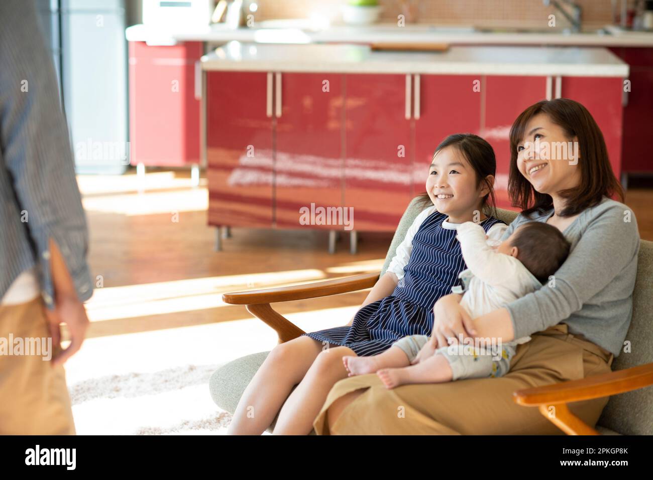 Smiling parents and children sitting on the sofa Stock Photo