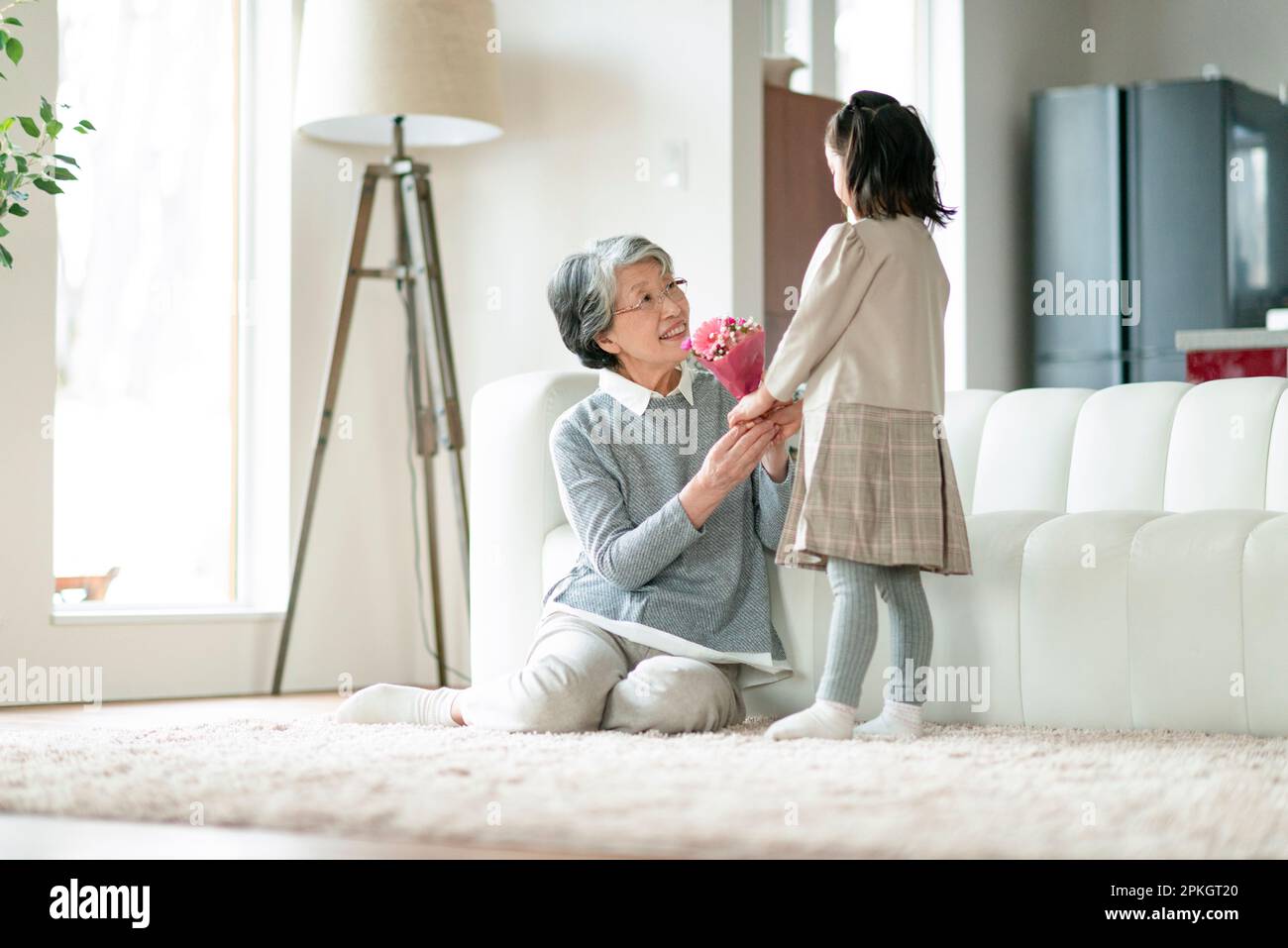 A grandmother receiving a bouquet of flowers from her grandchild Stock Photo