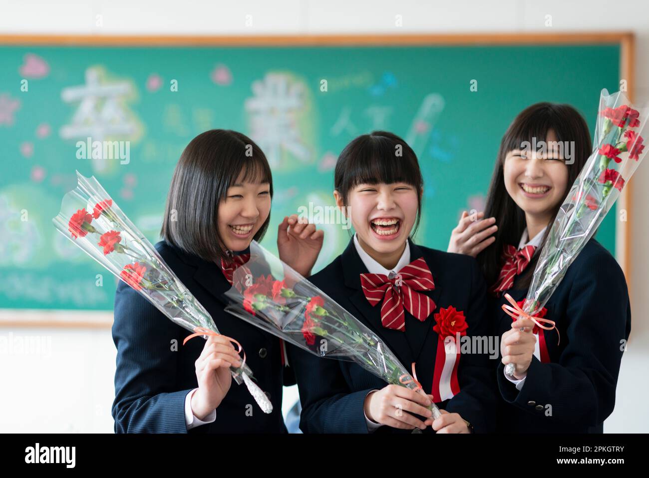Female student holding and smiling at a flower Stock Photo