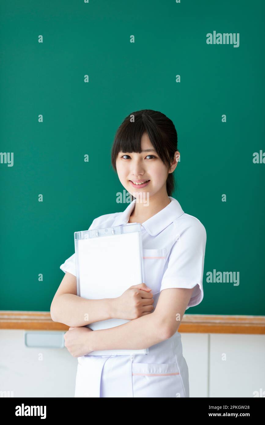 A smiling nursing student in front of the blackboard Stock Photo