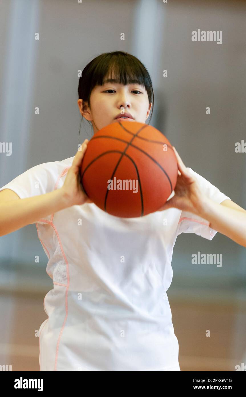 Female student playing basketball in gymnasium Stock Photo Alamy