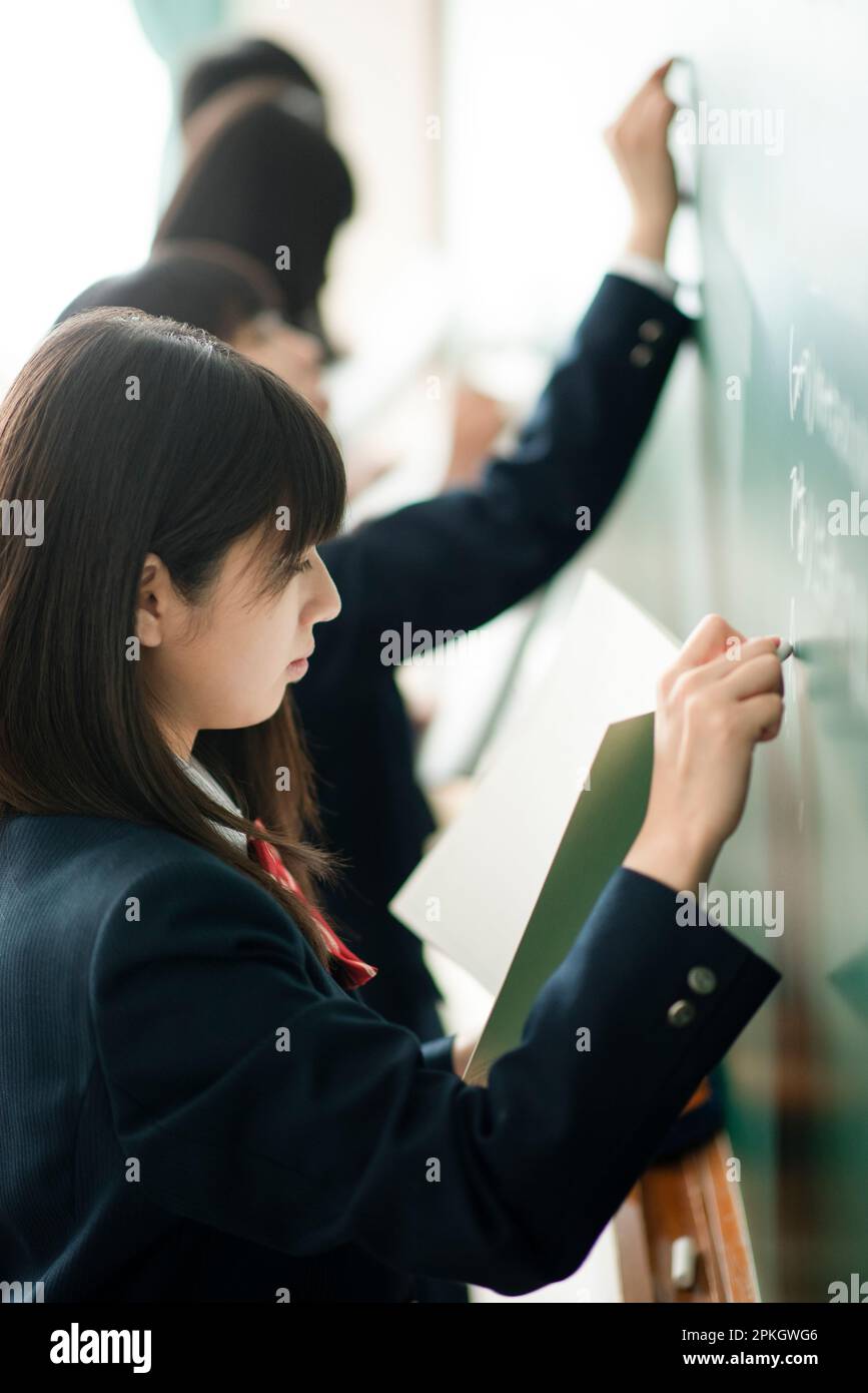 Chalk Writing Answer Female student writing answers on the blackboard with chalk Stock Photo ...