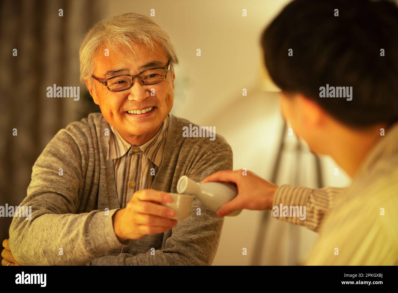 Parent and child having an evening drink with sake Stock Photo Alamy