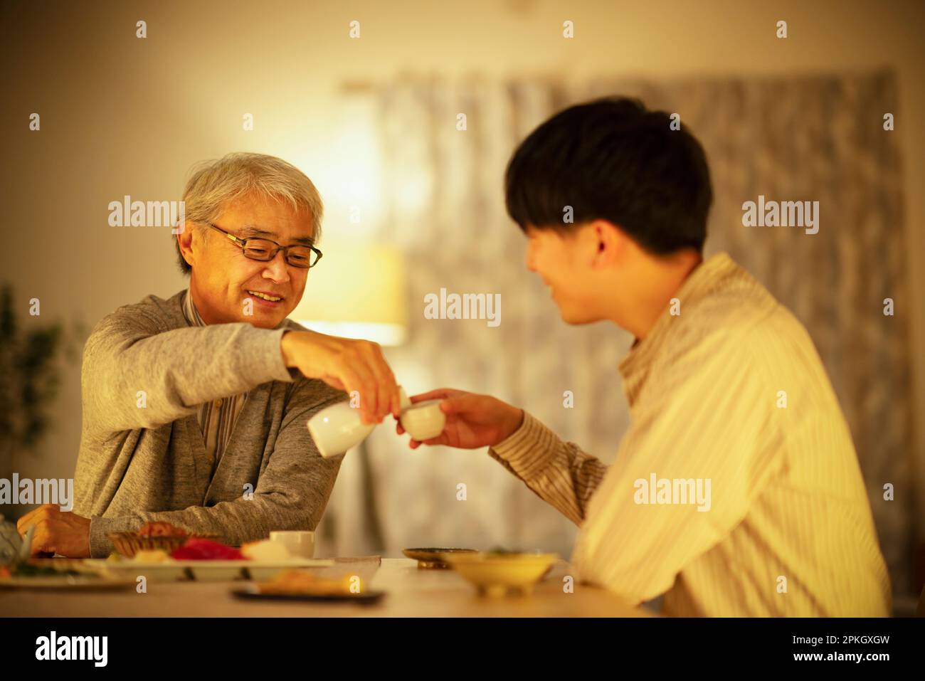 Parent and child having a drink with sake Stock Photo Alamy