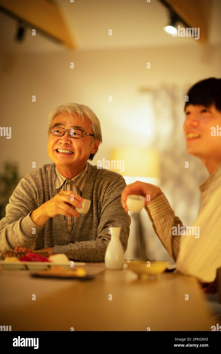 Parents and children drinking sake with dinner Stock Photo