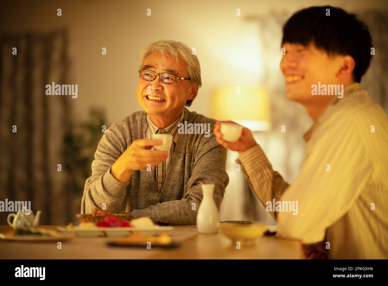 Parents and children drinking sake with dinner Stock Photo