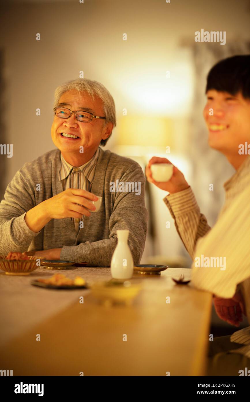 Parents and children drinking sake with dinner Stock Photo