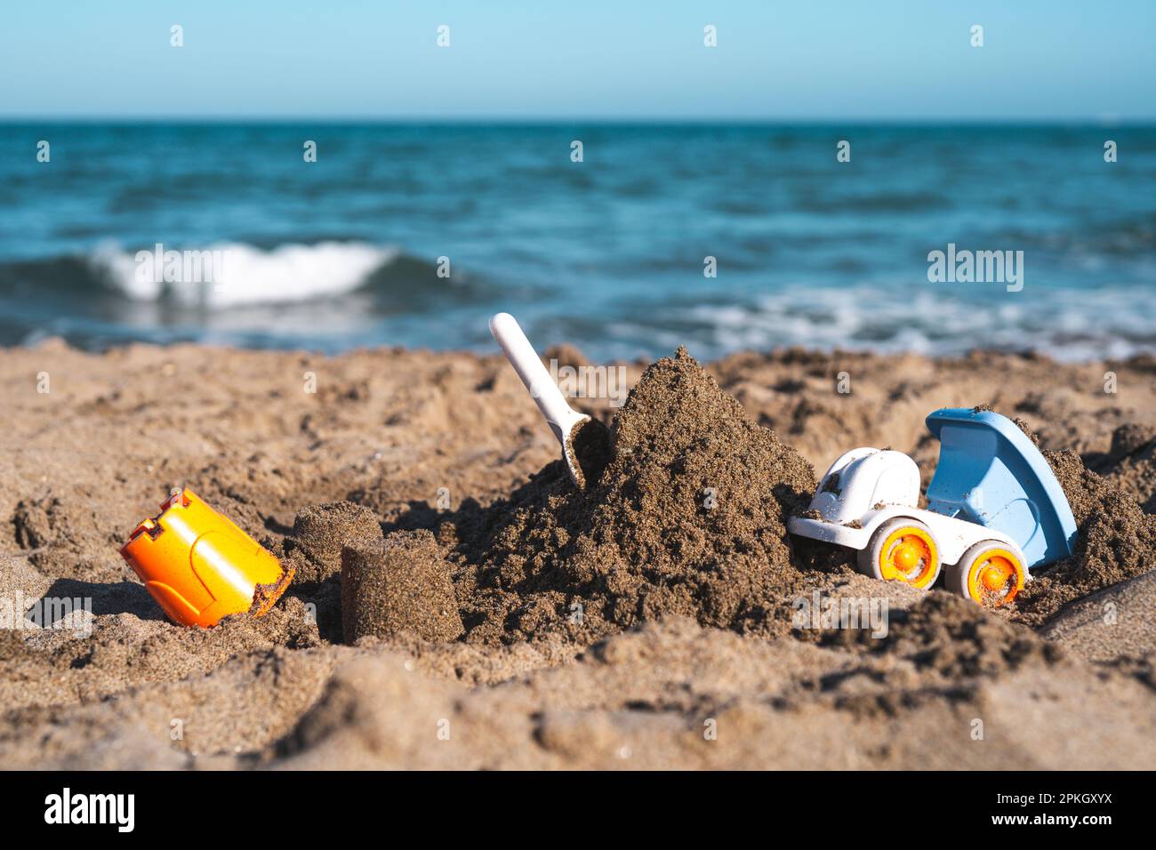 children's toys lie in the sand on the seashore Stock Photo