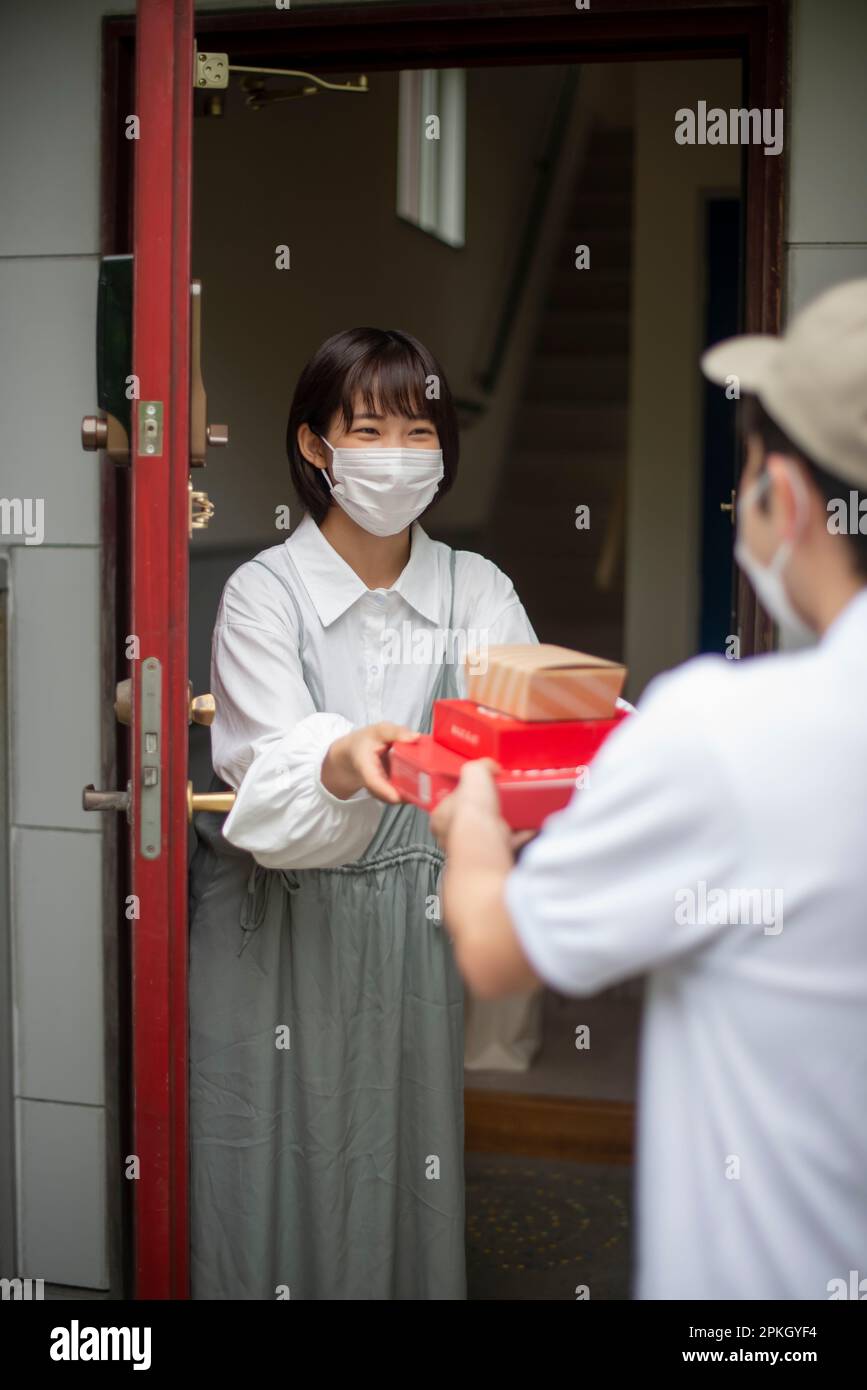 Woman receiving delivery at front door Stock Photo