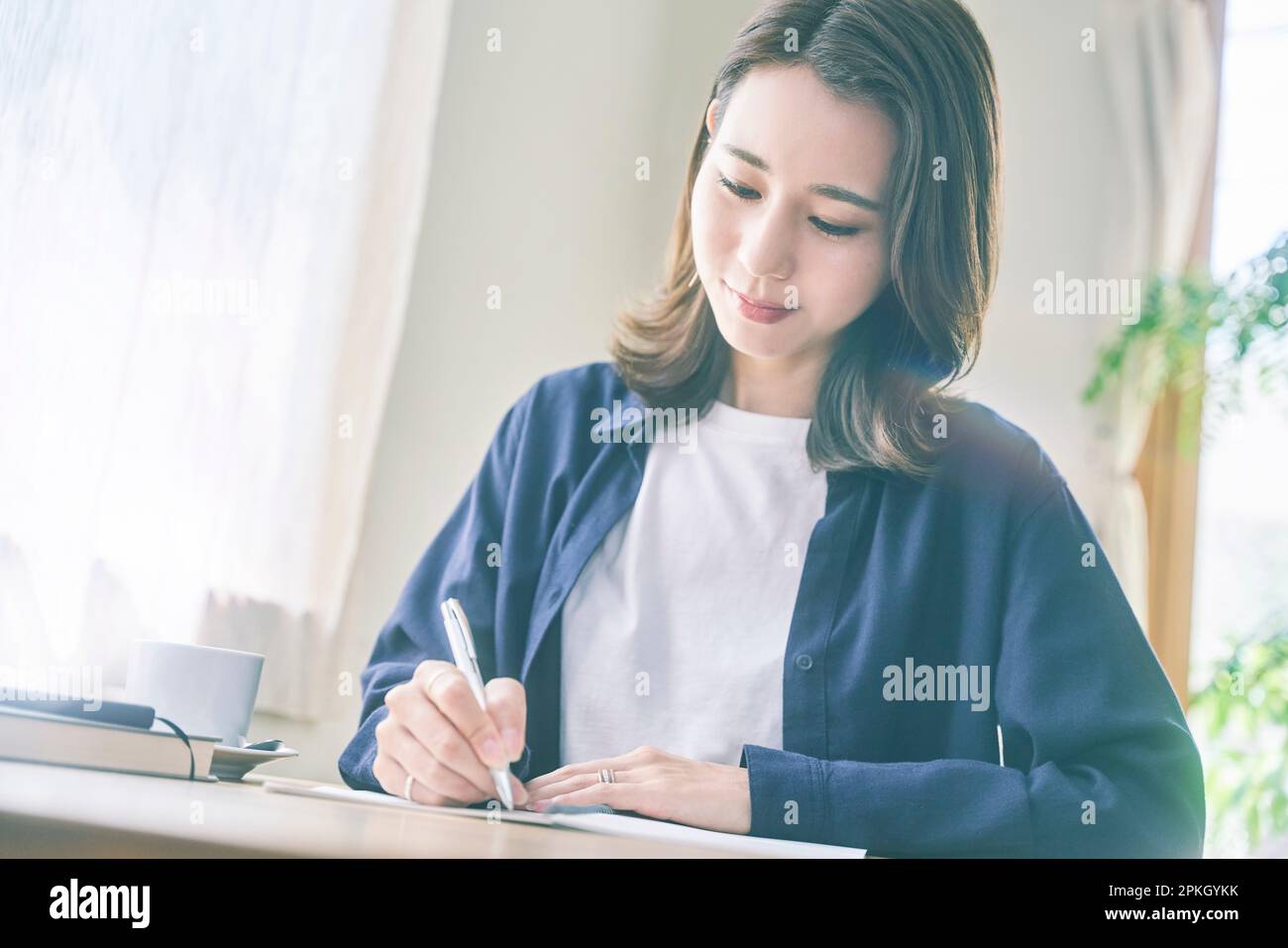 Woman writing notes at cafe Stock Photo