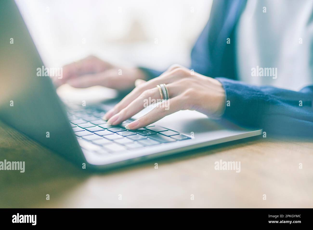 Woman operating laptop indoors Stock Photo