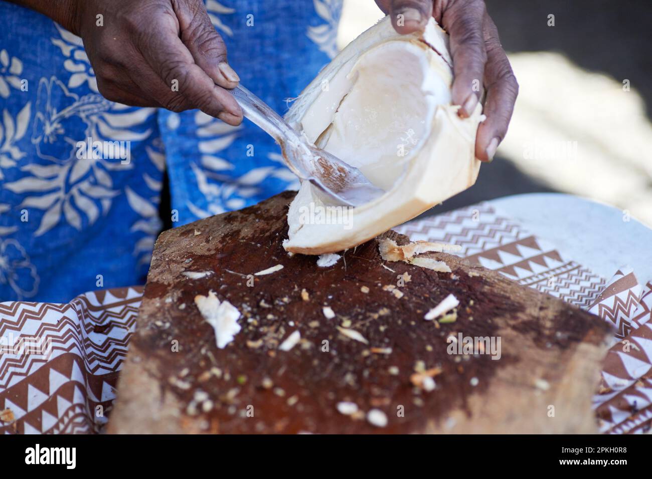 A Man scooping out the meat of a fresh picked young coconut Stock Photo Alamy