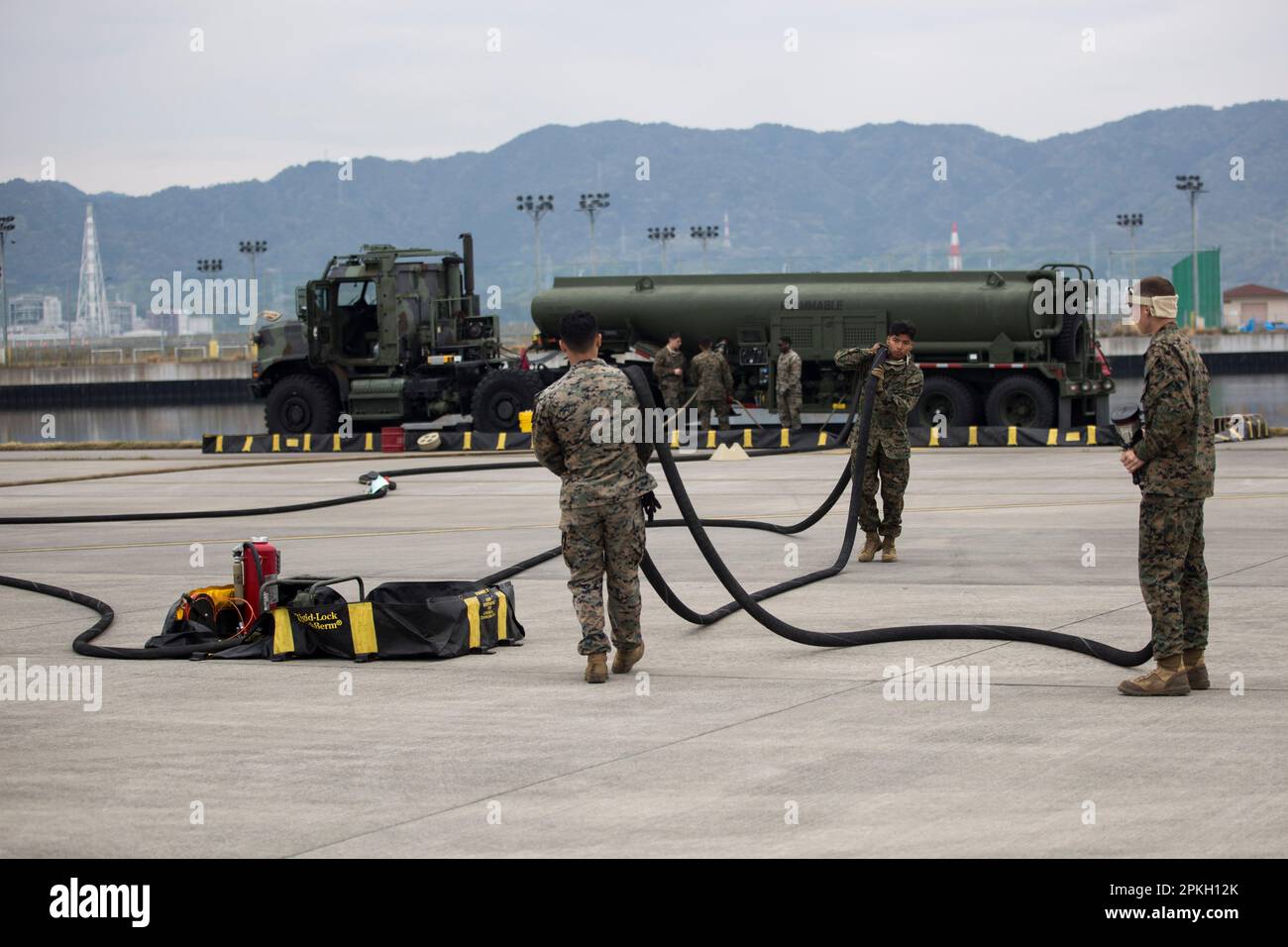 U.S. Marines with Marine Wing Support Squadron 171 carry fueling hoses to refuel an F-35B Lightning II aircraft at Marine Corps Air Station, Iwakuni, Japan, april 5, 2023. Marines with Marine Aircraft Group 12 routinely conduct arming, expeditionary refueling and flight operations to maintain proficiency and readiness in support a free and open Indo-Pacific. (U.S. Marine Corps photo by Lance Cpl. Samantha Rodriguez) Stock Photo