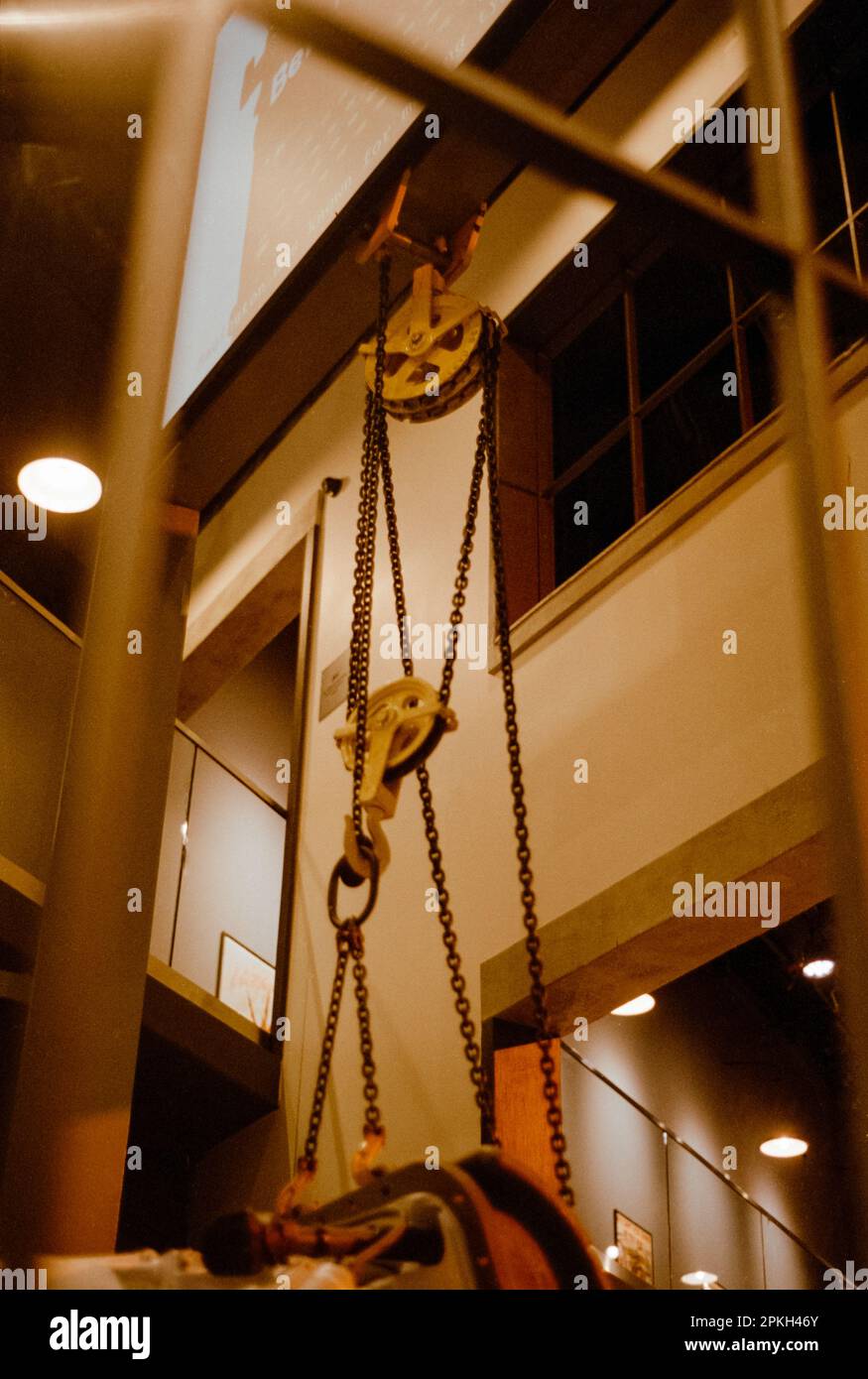 A block and tackle holds vintage airplane engines in the air between