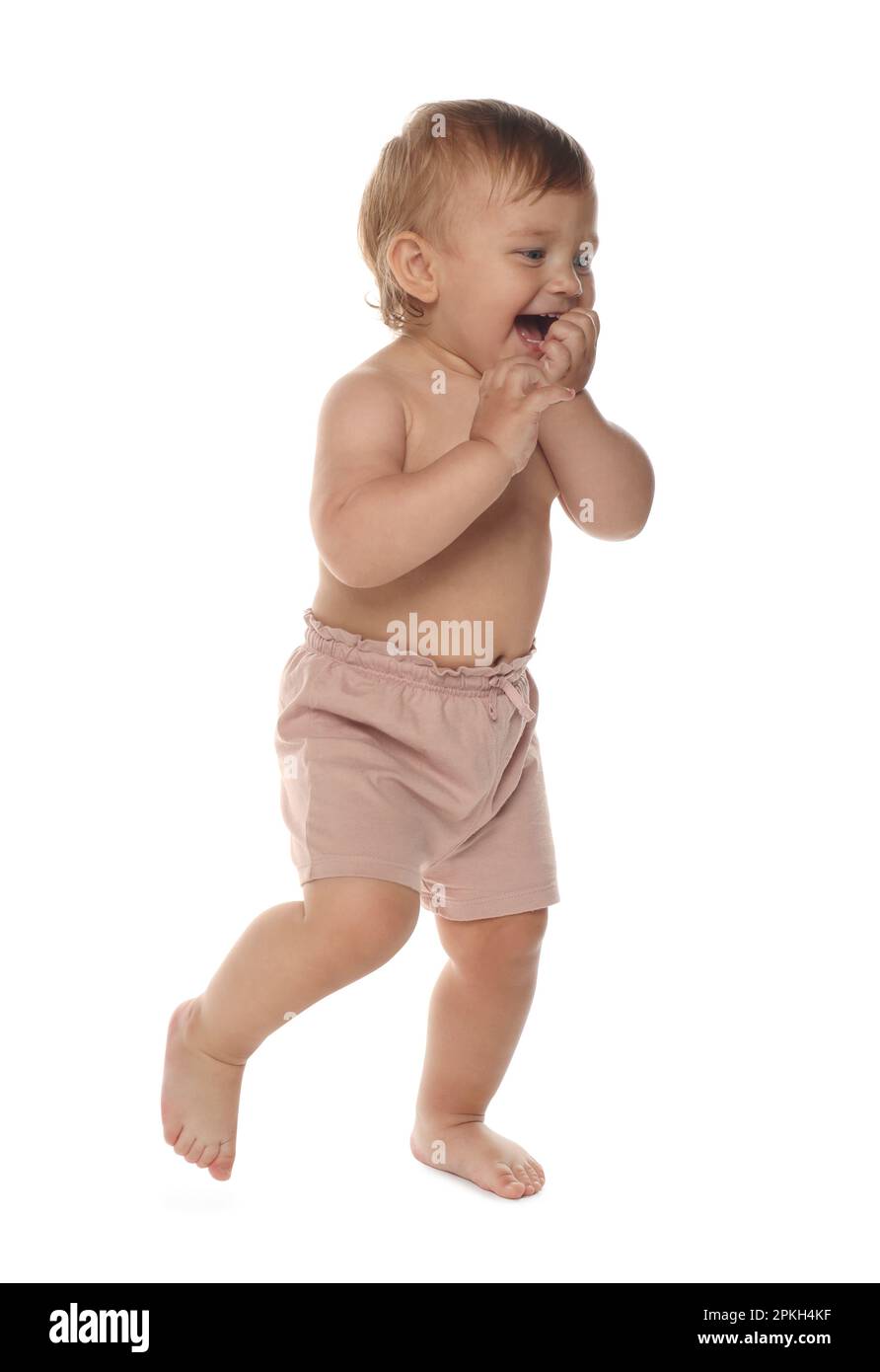 Cute baby in shorts learning to walk on white background Stock Photo