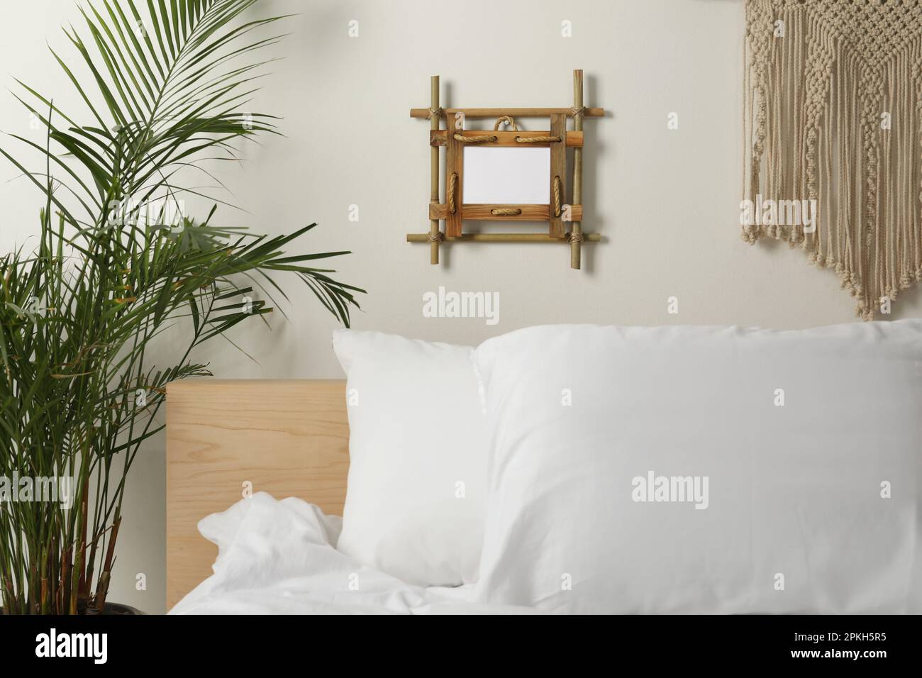 Empty bamboo frame hanging on white wall in bedroom Stock Photo - Alamy