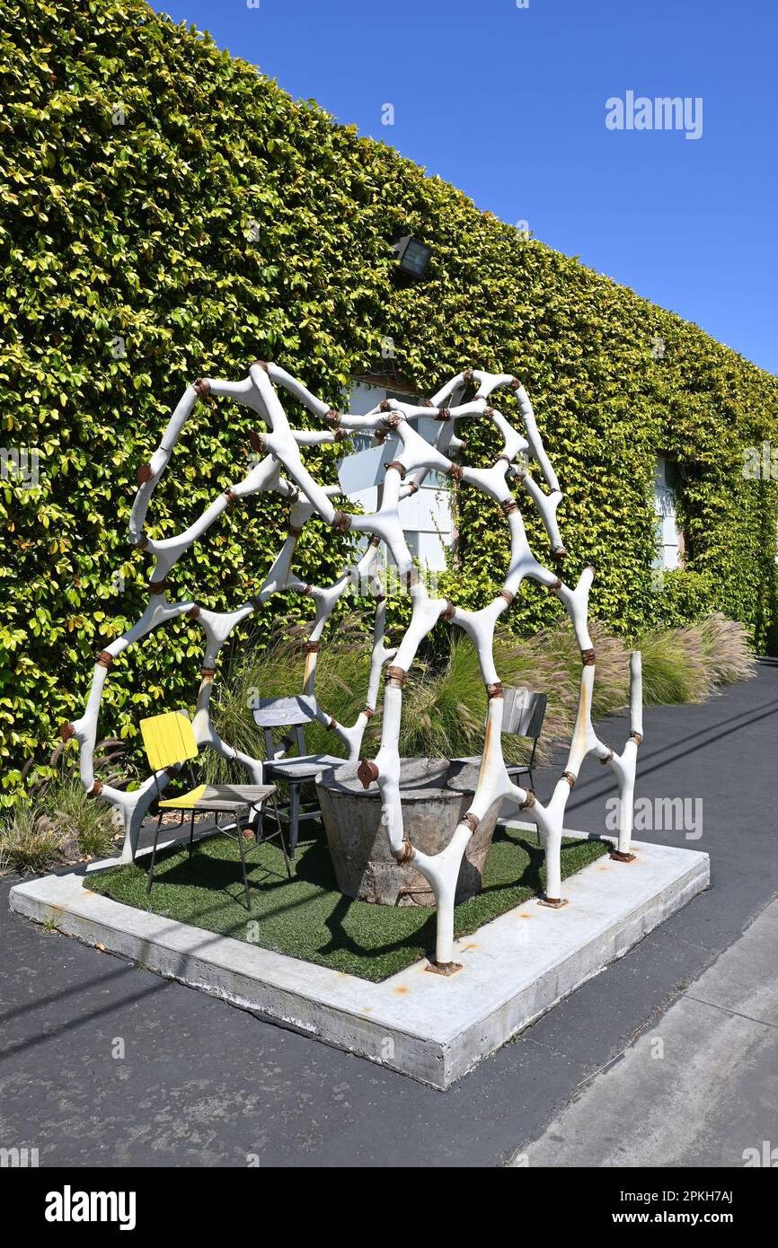 COSTA MESA, CALIFORNIA - 4 APR 2023: Dinosaur skeleton sculpture with table and chairs at The LAB Anti Mall. Stock Photo