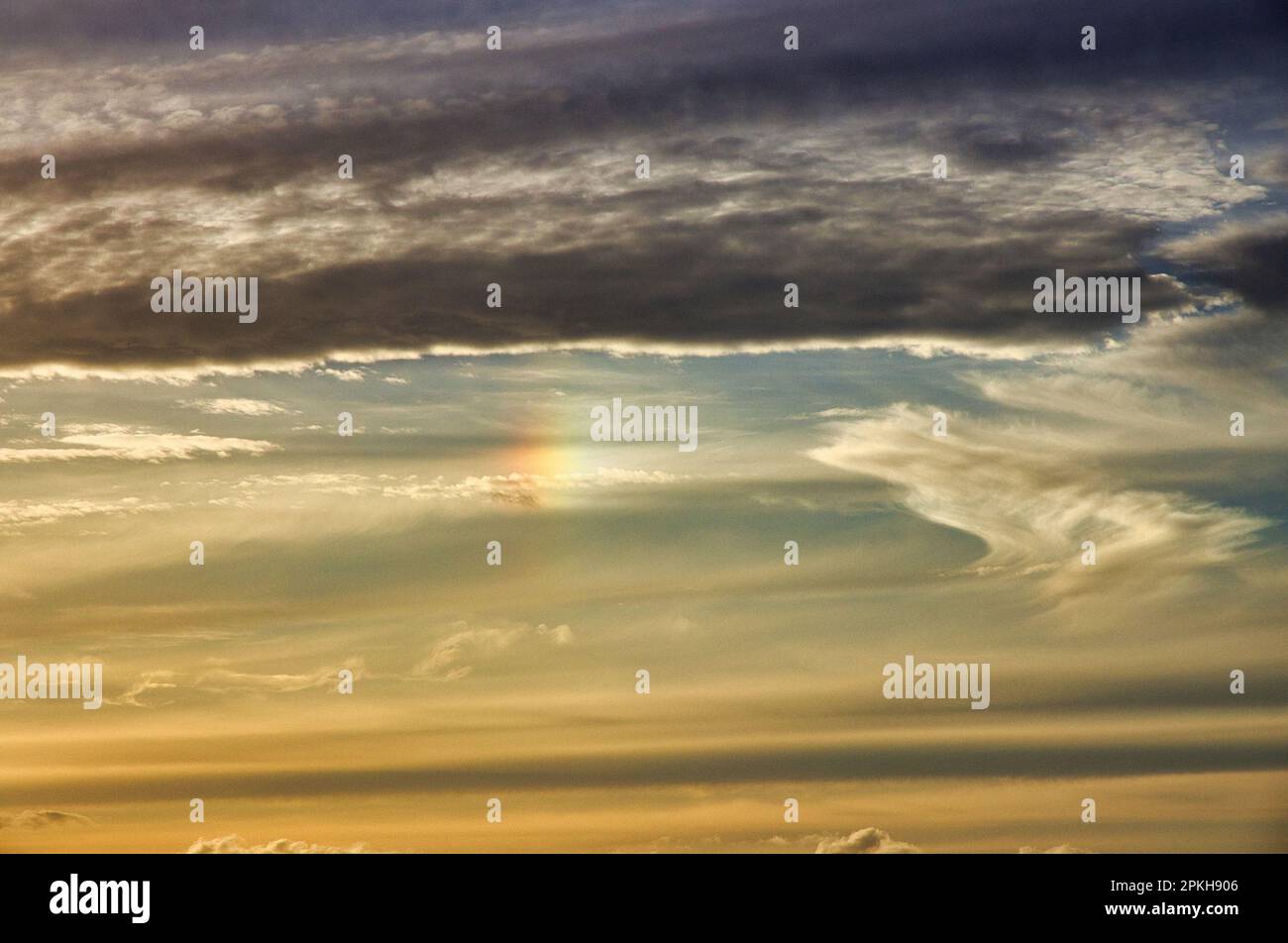 Beautiful sunset sky with small burst of rainbow light. Stock Photo