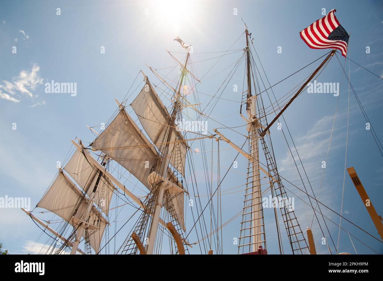 Backlit high-masted sails on tall sailing ship. Stock Photo
