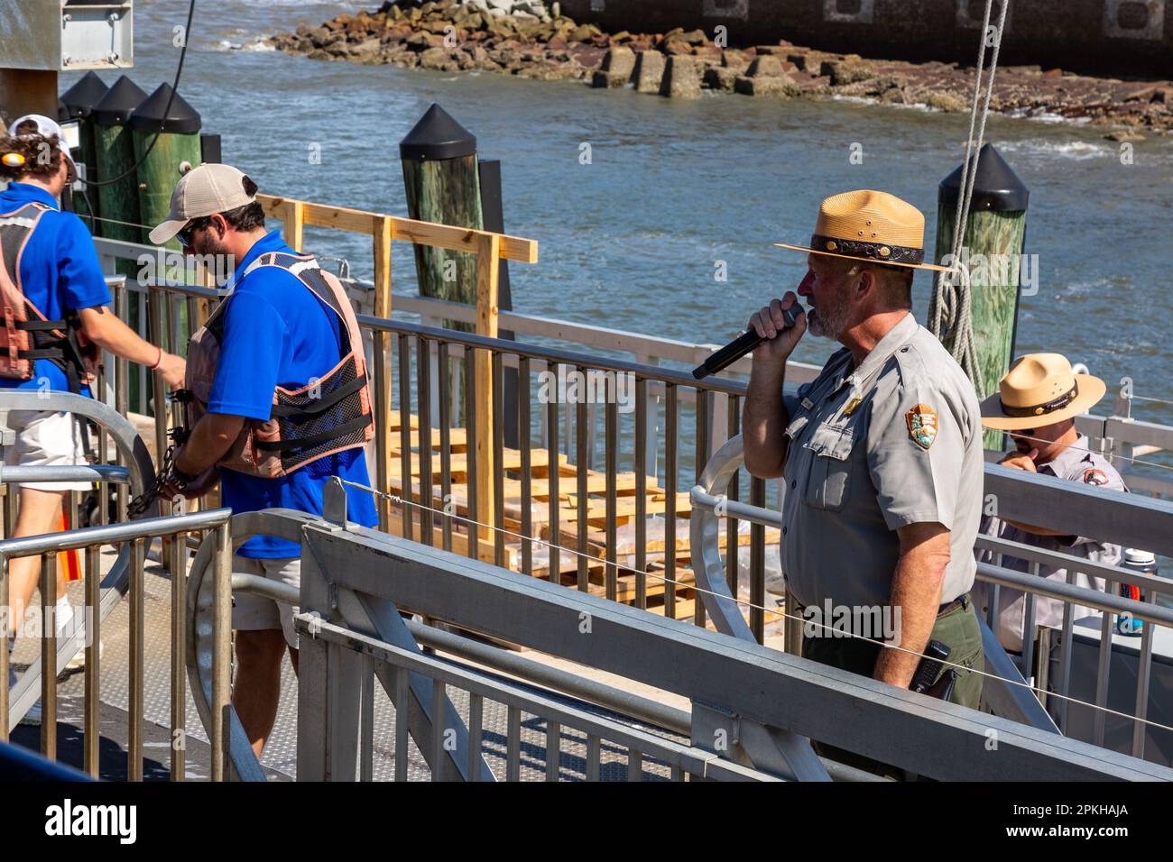 The ferry crew secures the boat while a park ranger welcomes visitors to the Fort Sumter National Monument in Charleston, South Carolina, USA Stock Photo