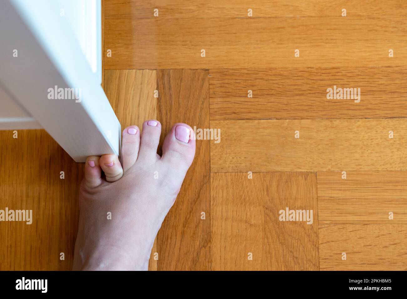 Woman hit furniture with the little toe. Incident at home. Injury of foot little finger Stock