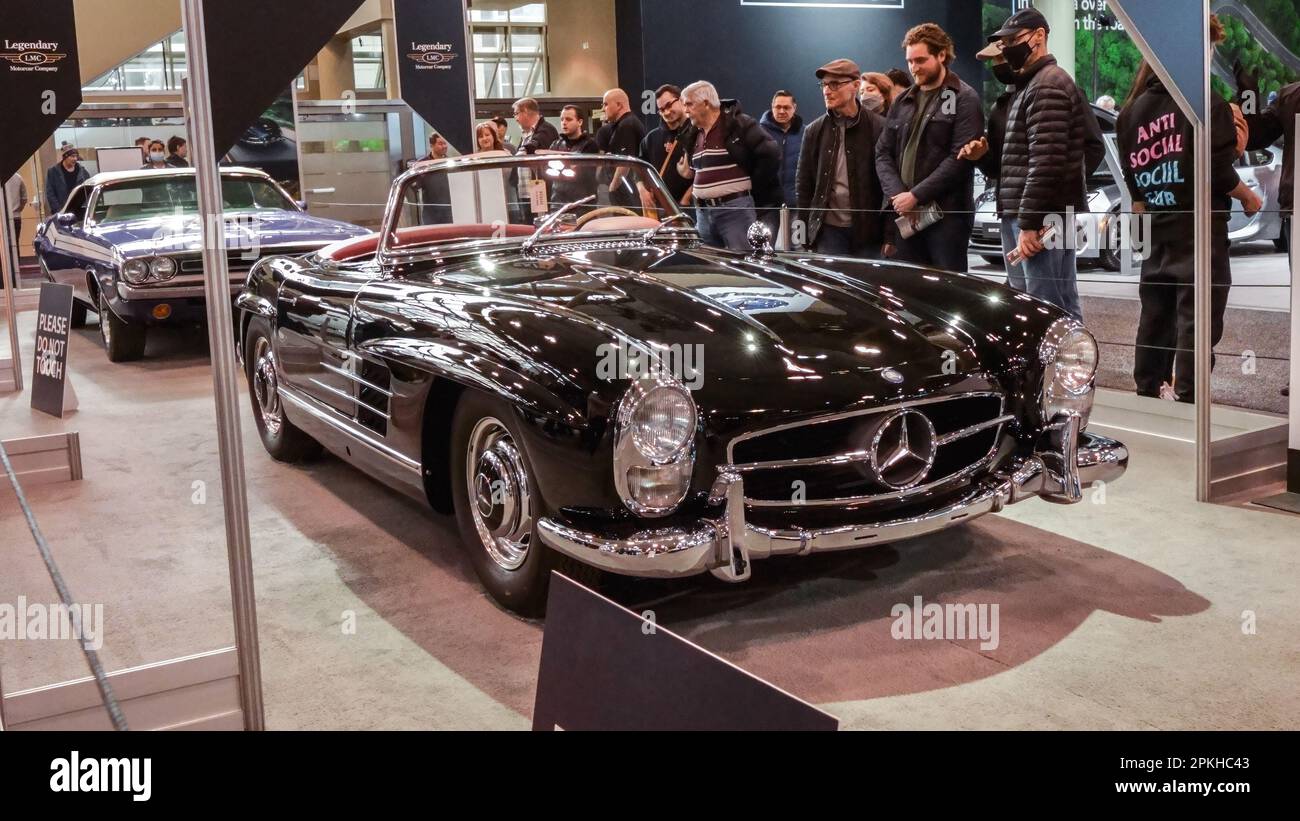 Crowds looking at new car models at Auto show. Mercedes vintage car on