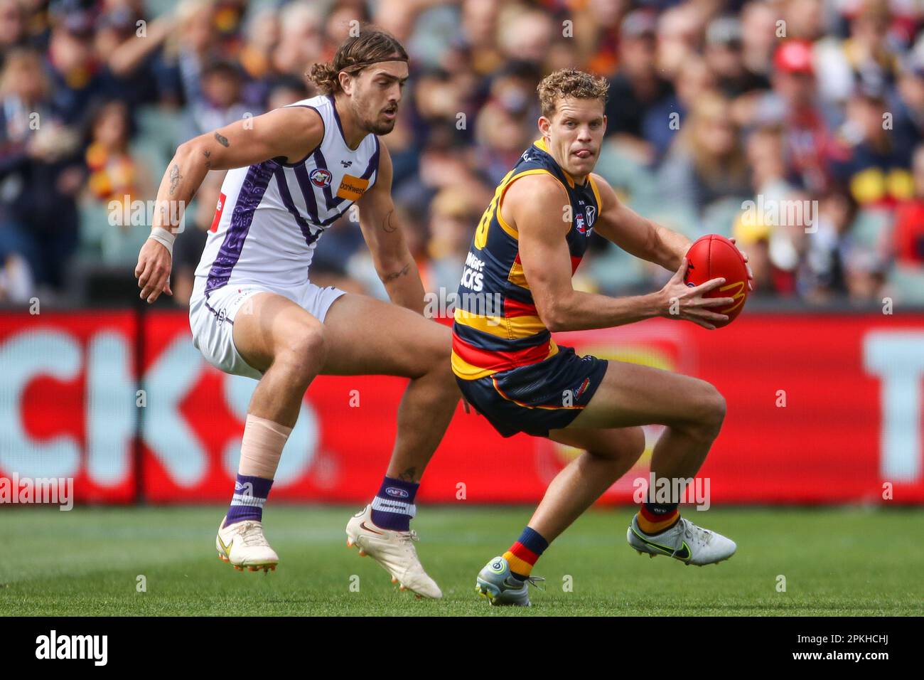 Mitch Hinge of the Crows evades Luke Jackson of the Dockers during the