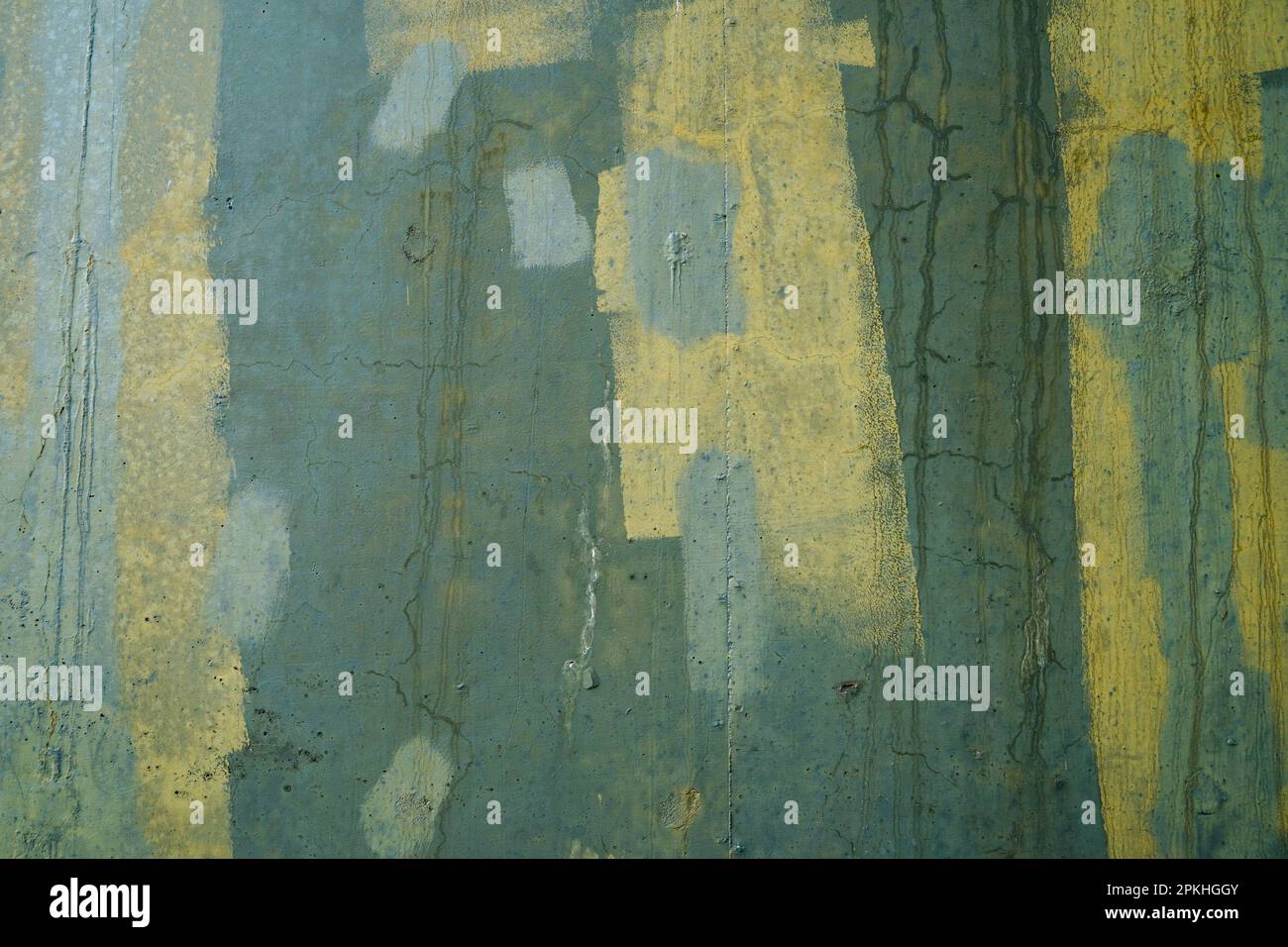 Abstract design of green and yellow paint covering graffiti on a