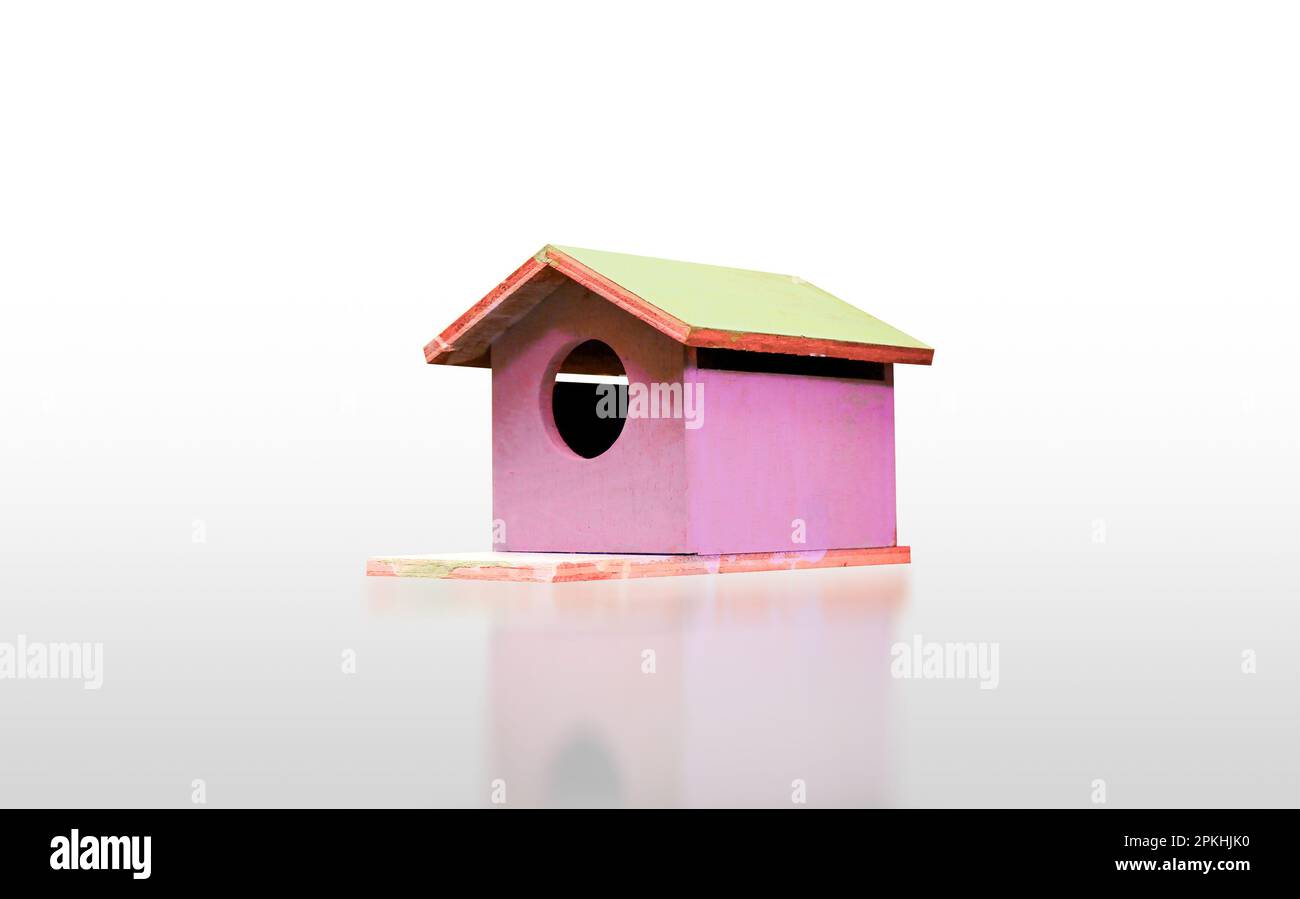Wooden sweet pink birdhouse isolated on white background with reflection, clipping path included. Stock Photo
