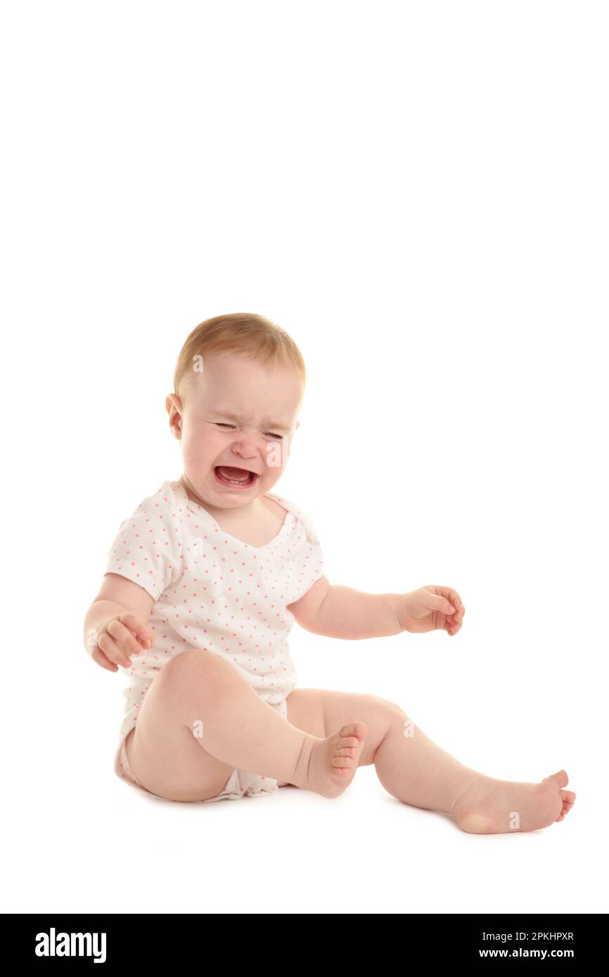 Sad baby girl sitting and crying isolated on white background. Top view Stock Photo