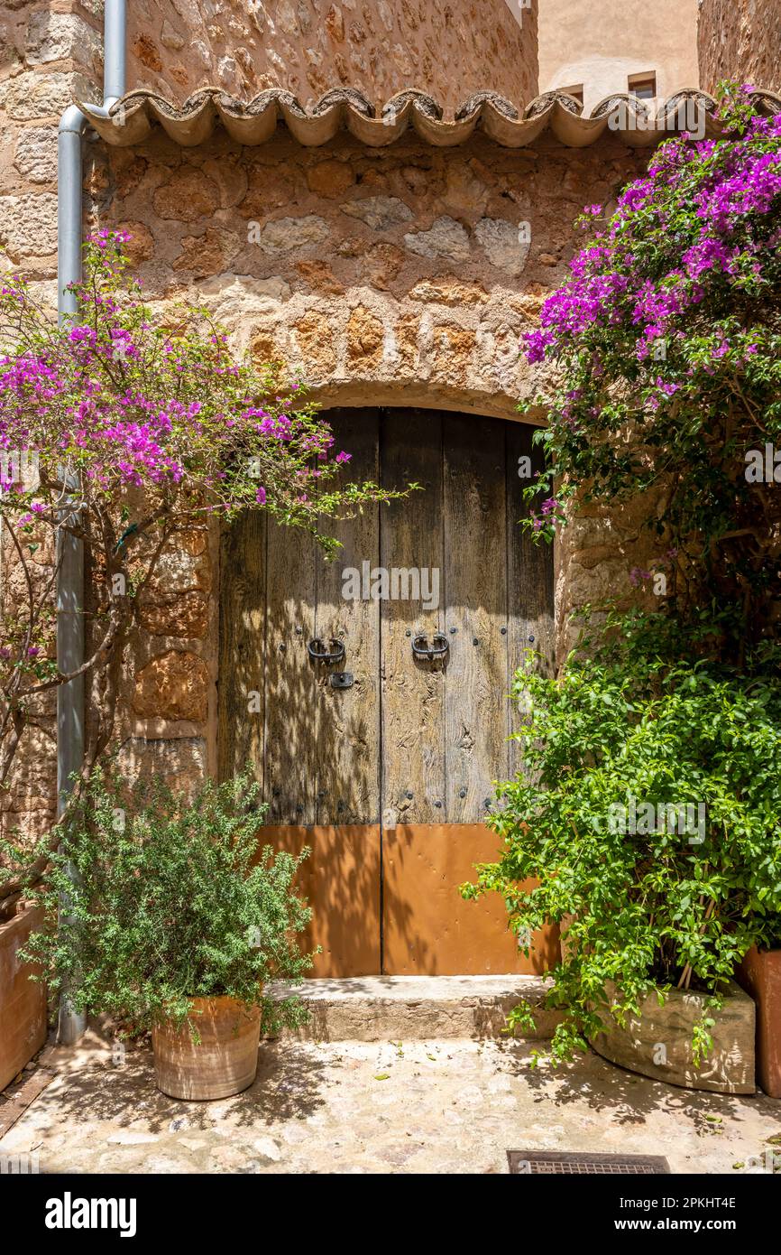 Entrance gate of a typical stone house with bougainvilleas, Fornalutx, Serra de Tramuntana, Majorca, Balearic Islands, Spain Stock Photo