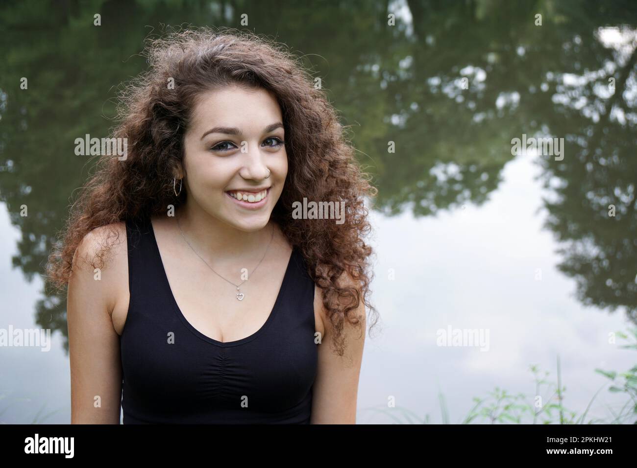 beautiful young spanish woman relaxing by a pond Stock Photo - Alamy