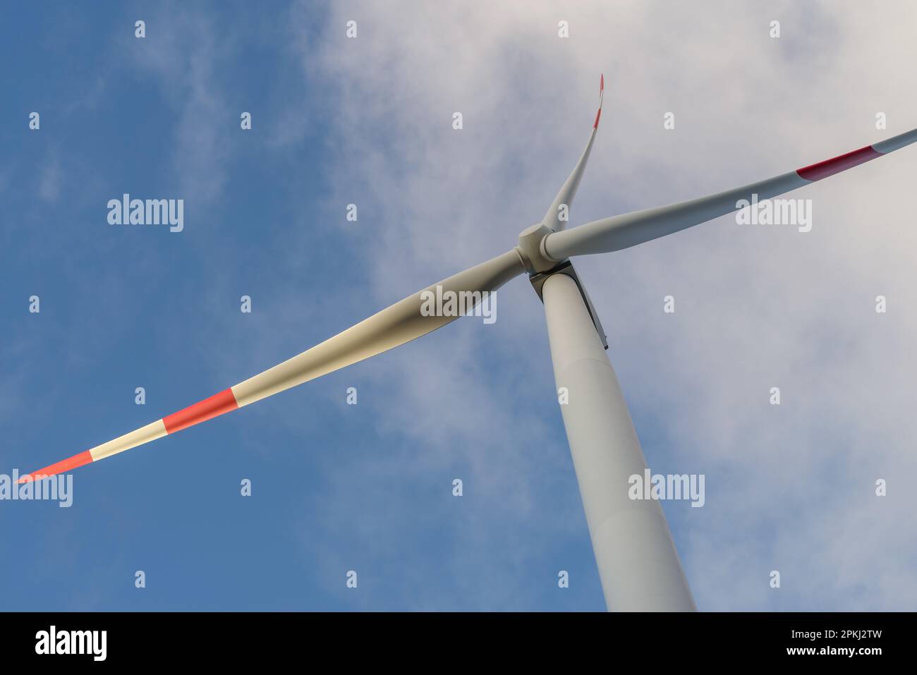 Wind turbine under clouds and blue sky Stock Photo - Alamy