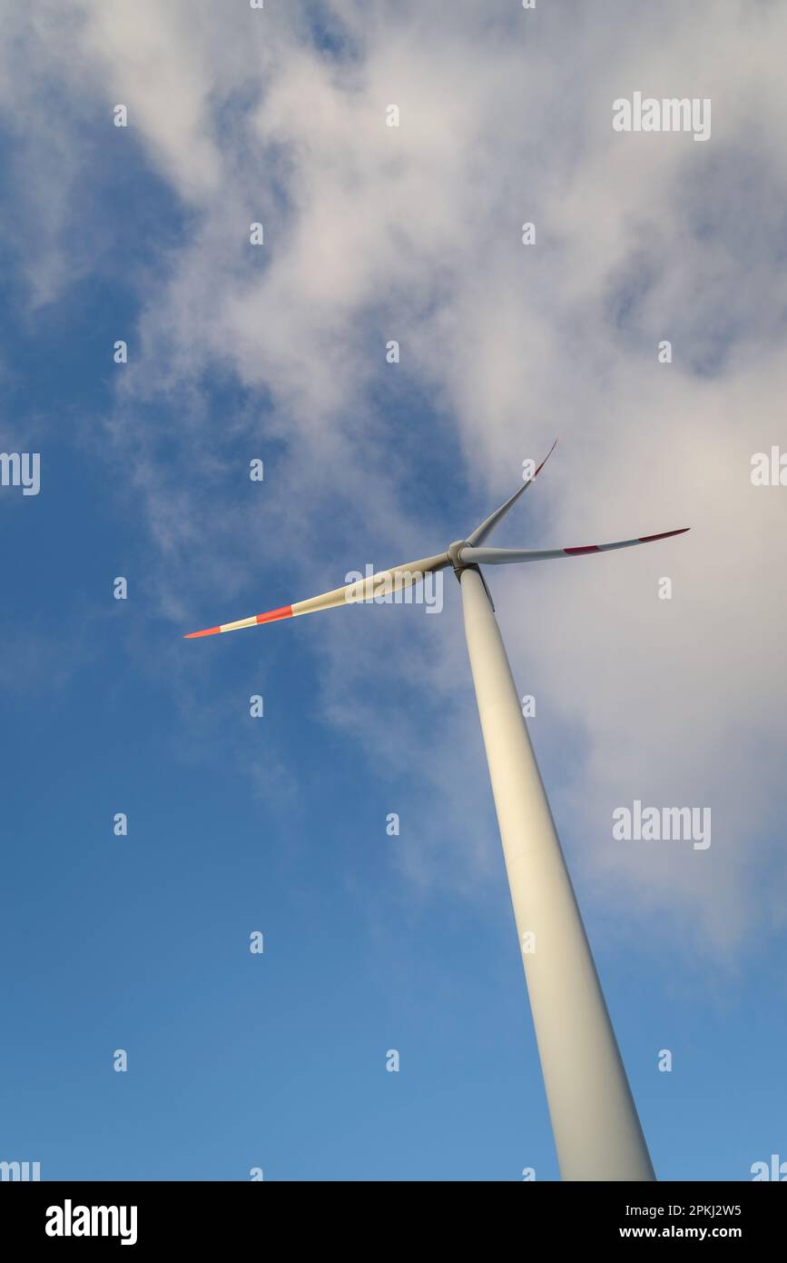 Wind turbine under clouds and blue sky Stock Photo - Alamy