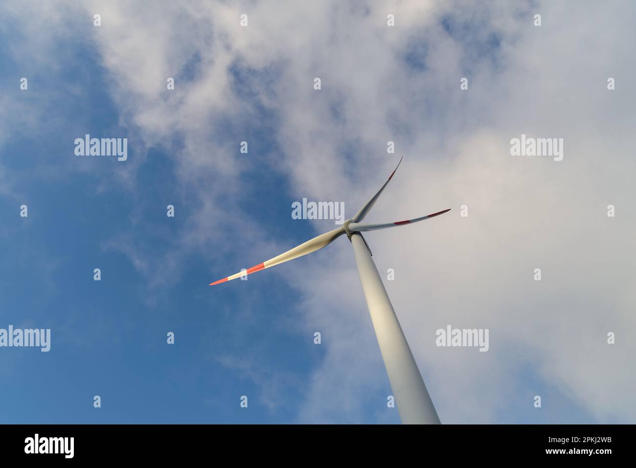 Wind turbine under clouds and blue sky Stock Photo - Alamy