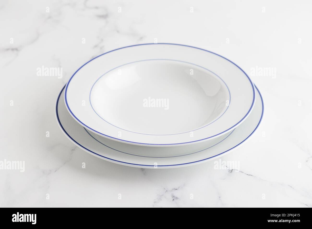 Empty white soup plate with blue stripe on a white background Stock Photo