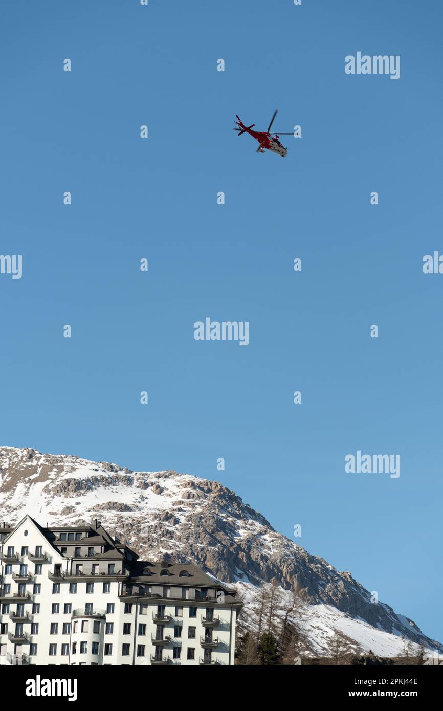 Saint Moritz, Switzerland, February 21, 2023 REGA air ambulance helicopter in the blue sky Stock Photo