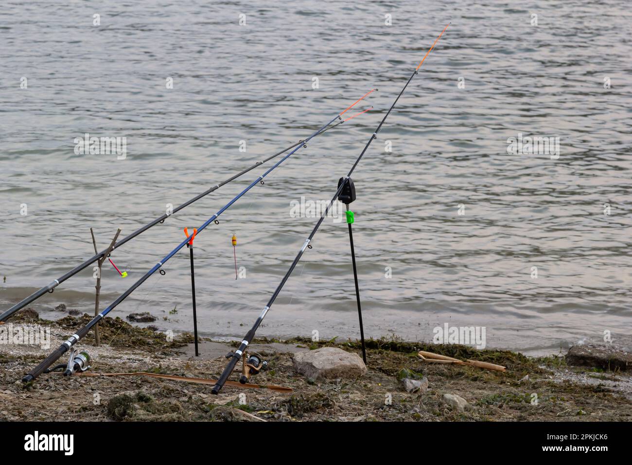 Fishing rods and fishing gear on the river bank, lake coast close