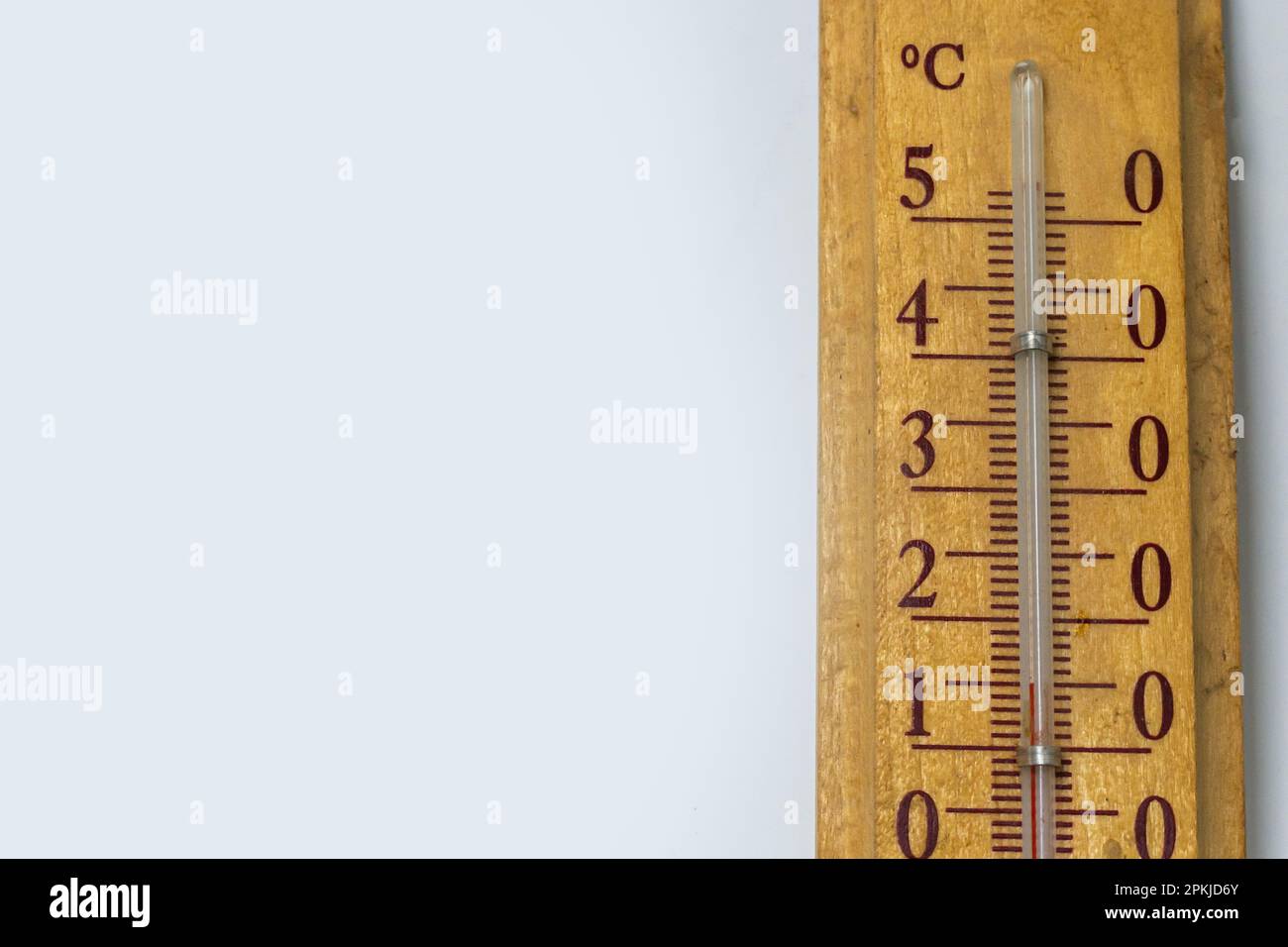 room thermometer on a wooden base close up on a white background. Celsius degree scale. Stock Photo