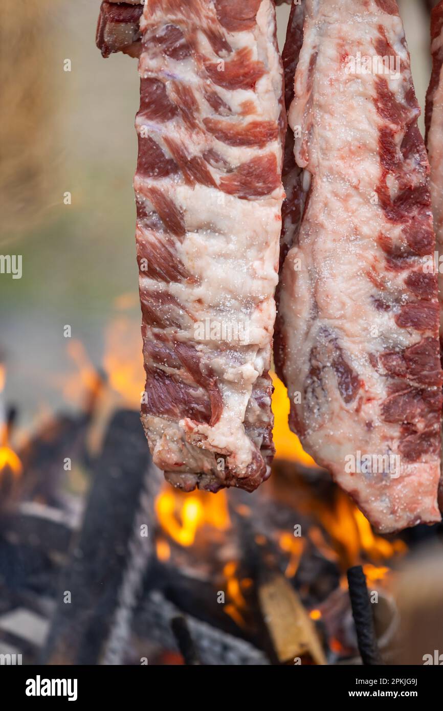 tasty rack of pork ribs cooking on barbecue fire, vertical frame Stock Photo Alamy
